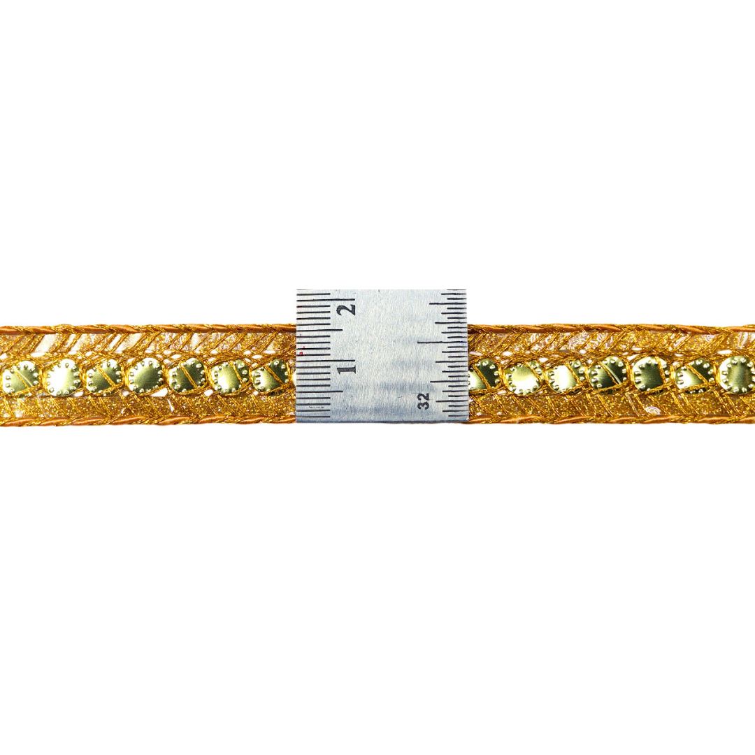 Gold belt with green gemstones and a ruler for size reference on a white background