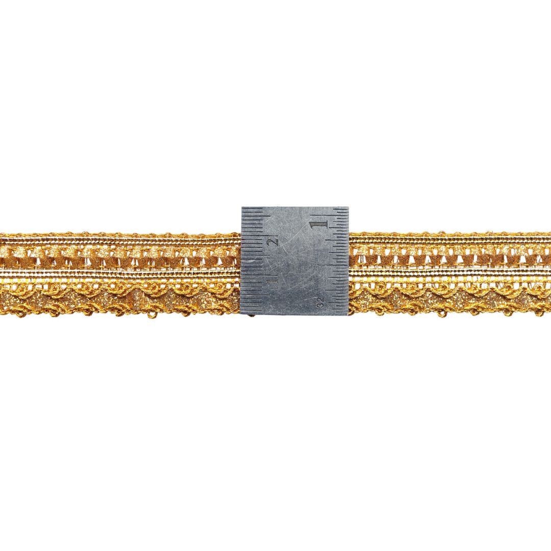 Decorative gold lace trim with a ruler for scale on a white background