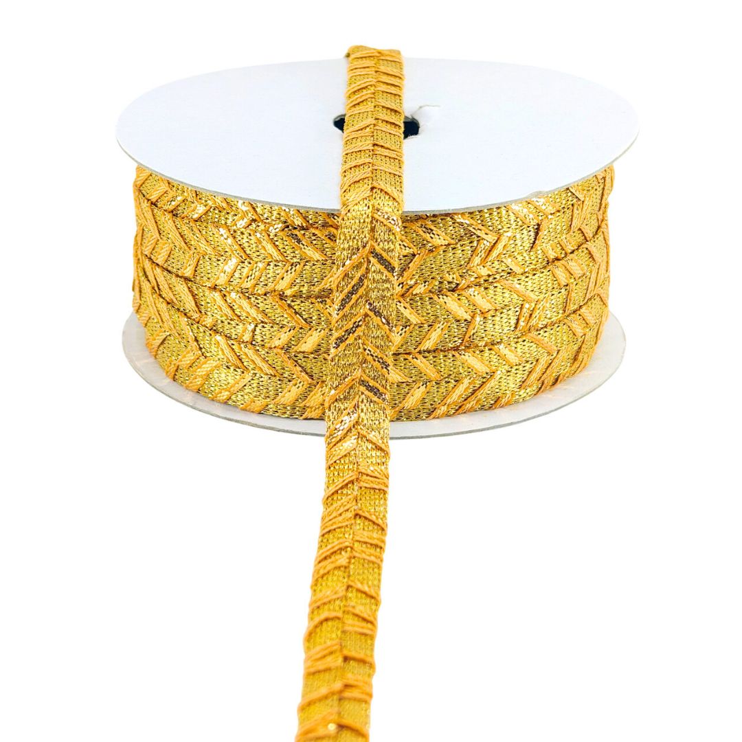 Gold braided cord on a white spool against a white background