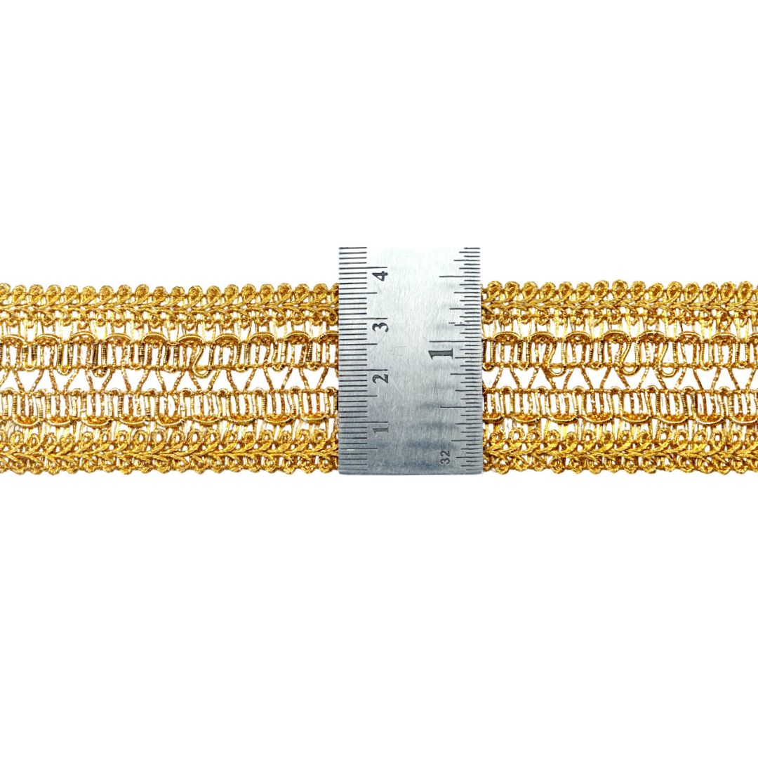 Gold braided trim with a ruler for measurement on a white background