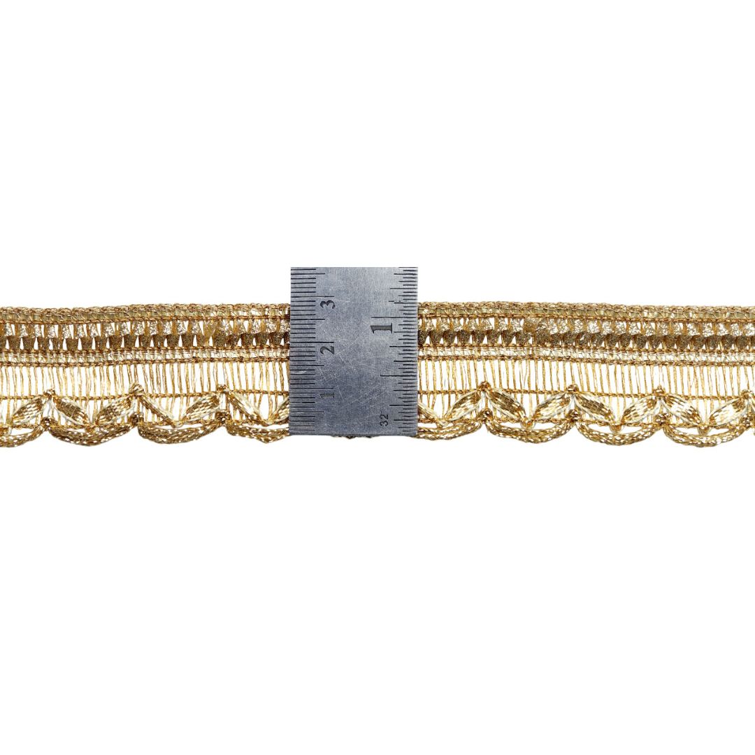 Gold lace trim with a ruler for measurement on a white background
