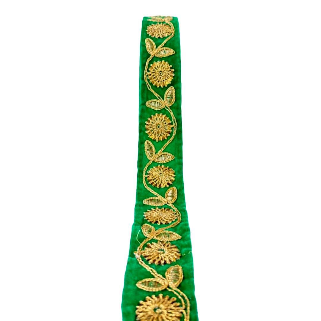 Green ribbon with gold floral embroidery on a white background