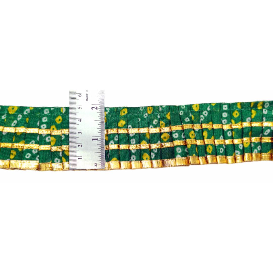 Green and gold woven belt with a ruler for scale on a white background