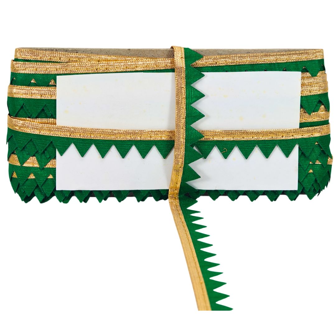 Green and gold decorative item with white center on a white background