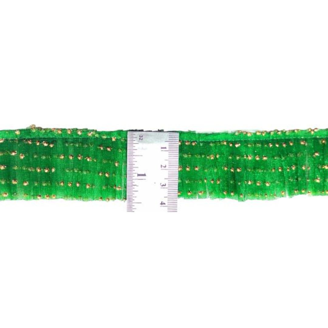 Green decorative trim with gold dots and a ruler for scale on a white background