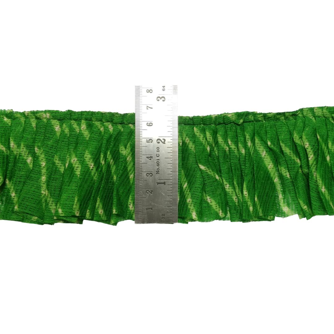 Green fabric with a zigzag pattern and a ruler for scale on a white background