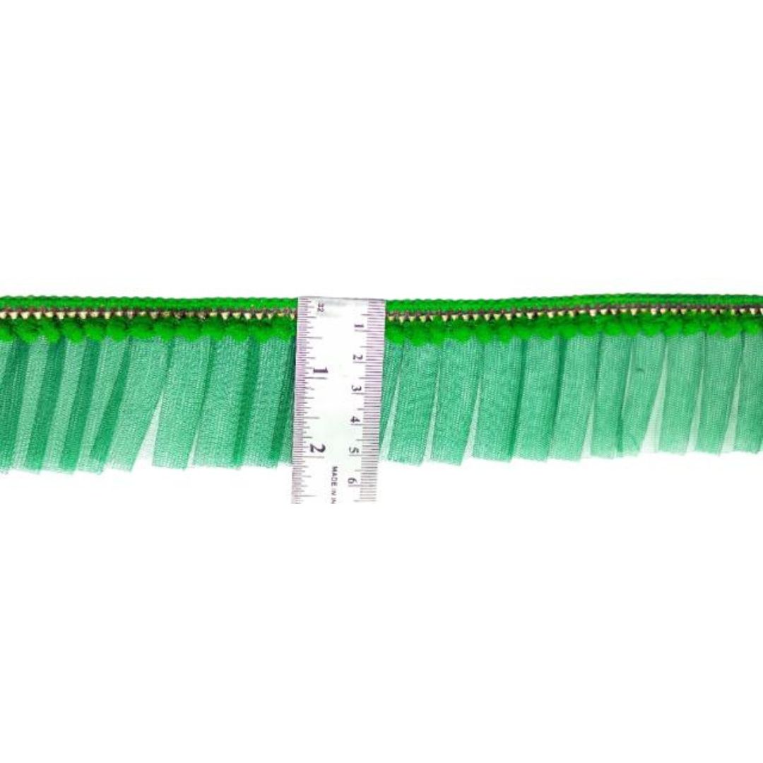 Green fringe trim with a ruler for scale on a white background