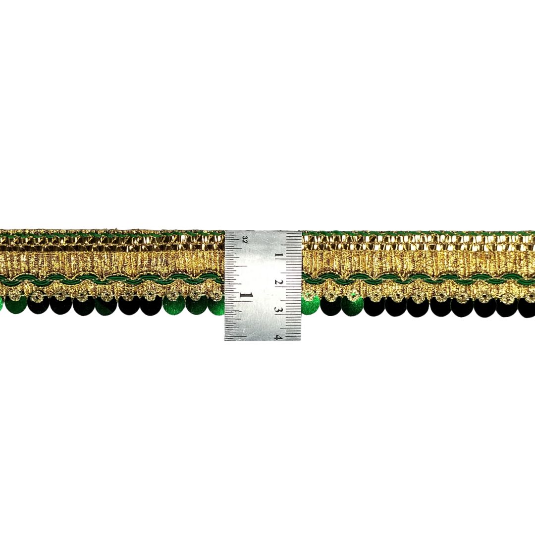 Decorative trim with gold and green pattern next to a ruler for measurement on a white background