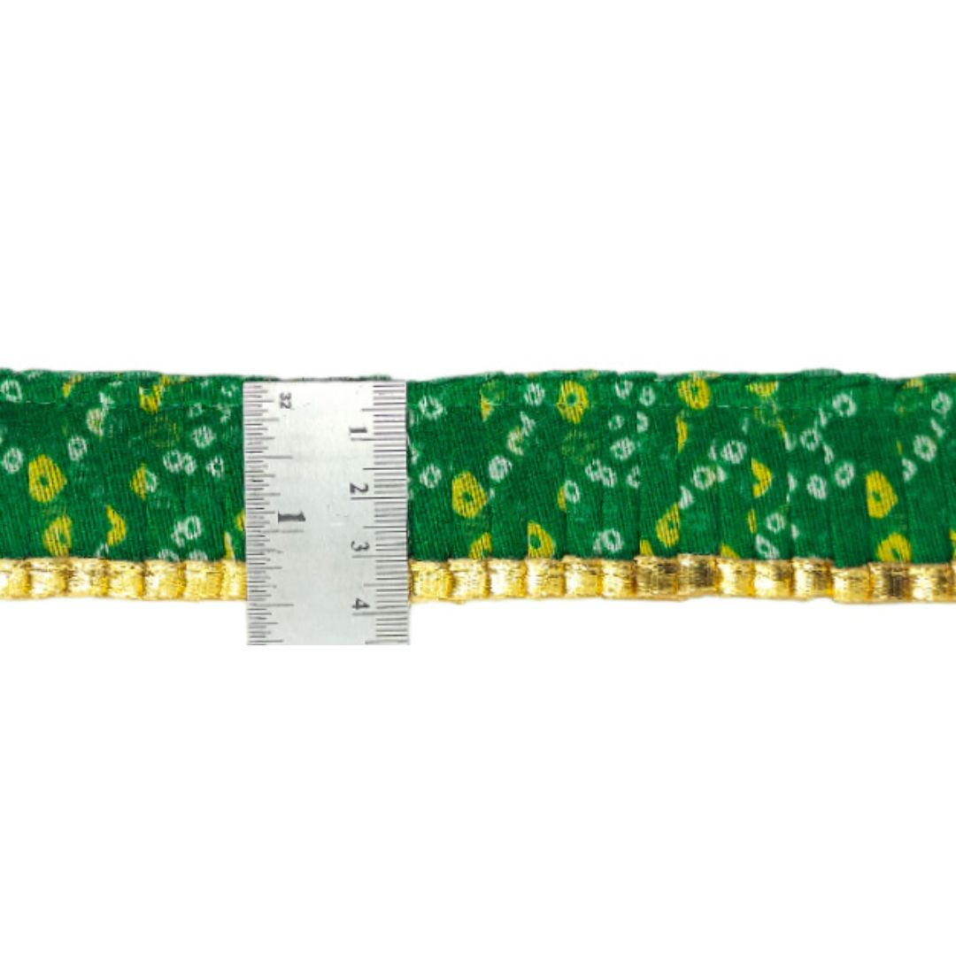 Green ribbon with gold trim and floral pattern, measured against a white background
