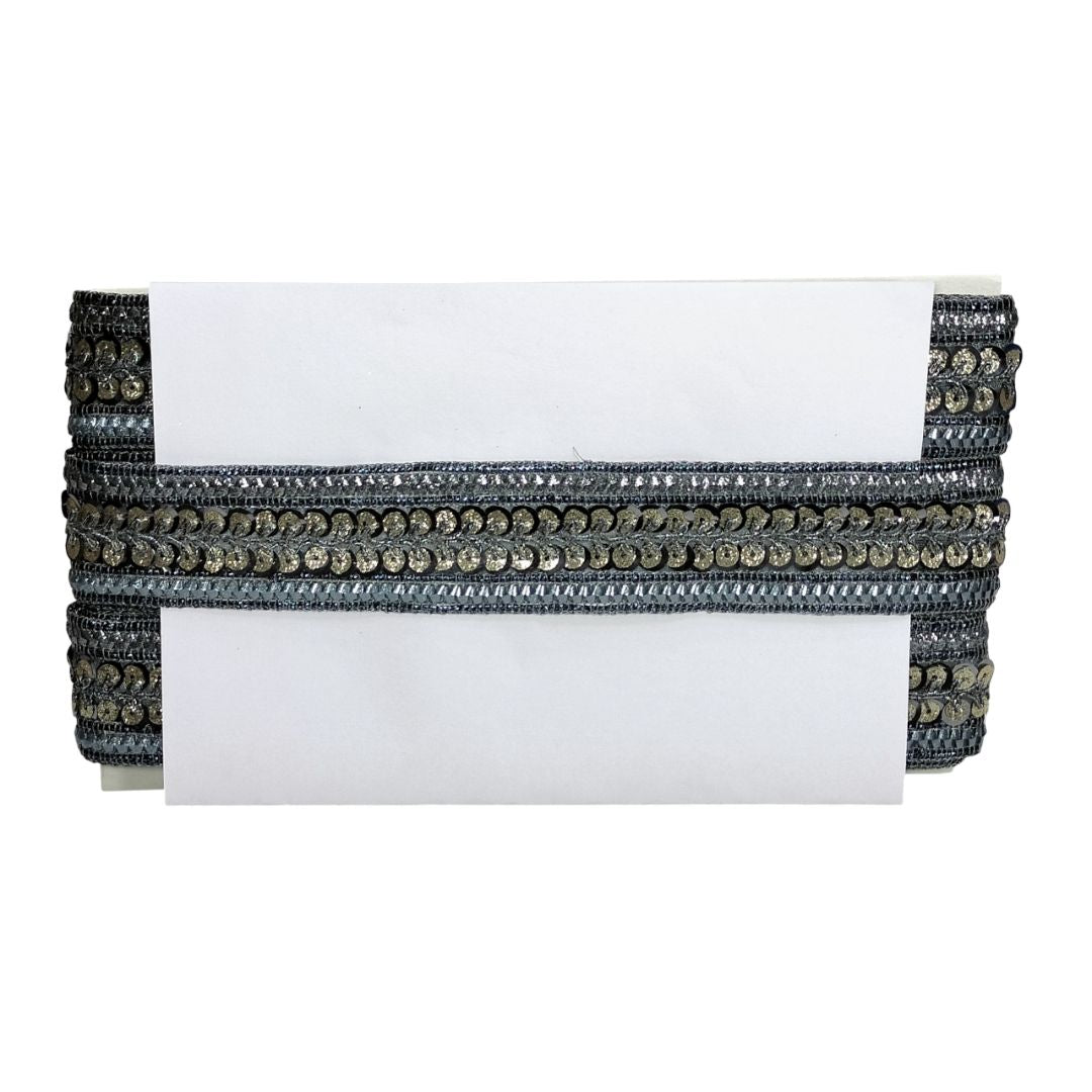 White clutch with black and gold embellishments on a white background