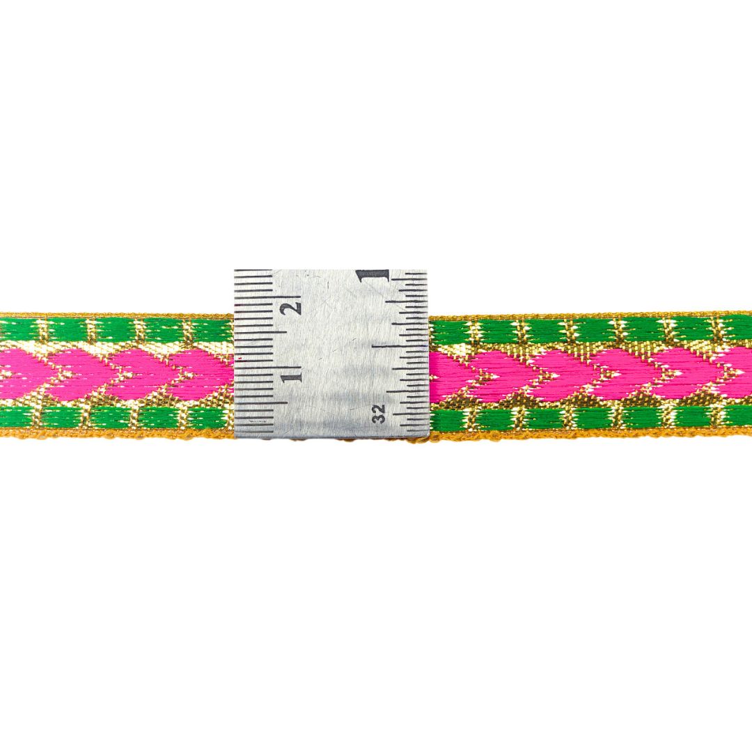 Woven belt with pink and green pattern next to a ruler on a white background