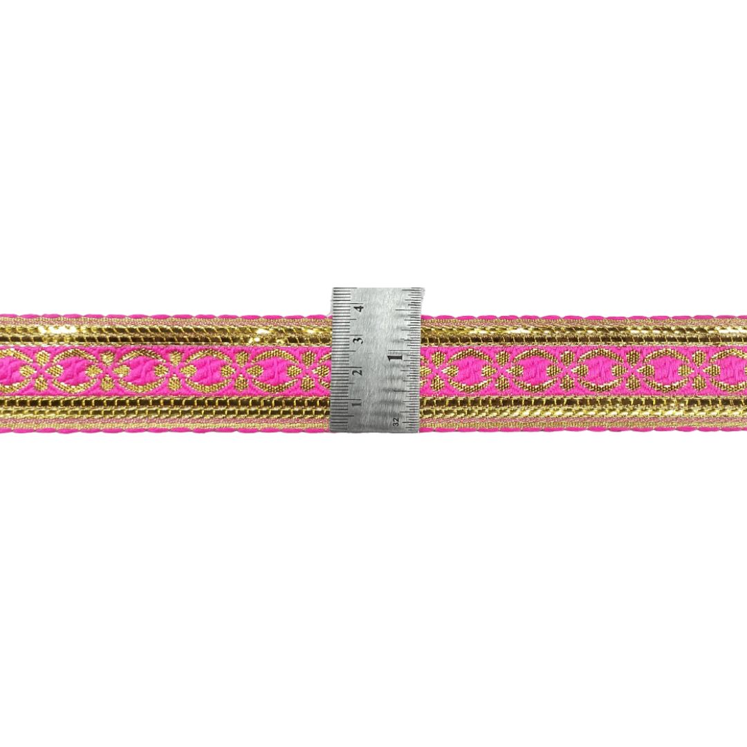 Pink and gold ribbon with a ruler for measurement on a white background