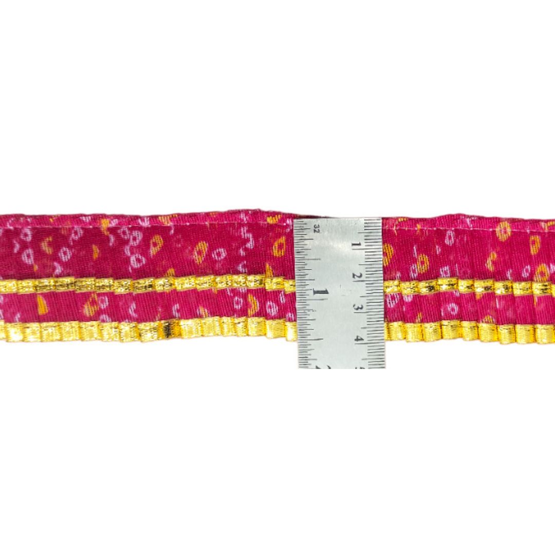 Pink and yellow patterned ribbon with a ruler for measurement on a white background