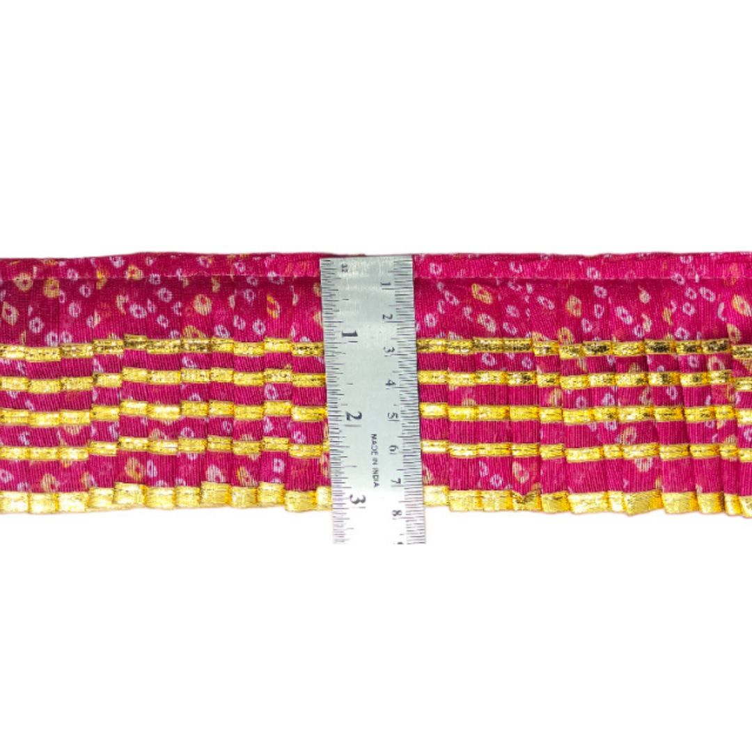 Pink and yellow patterned fabric with a ruler for scale on a white background