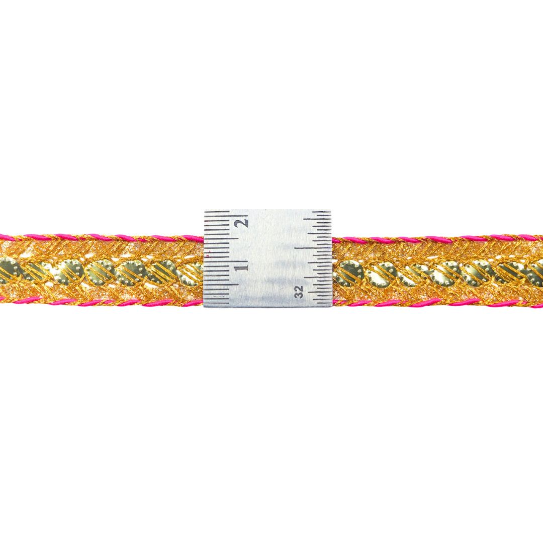 Gold and pink braided cord with a ruler for scale on a white background