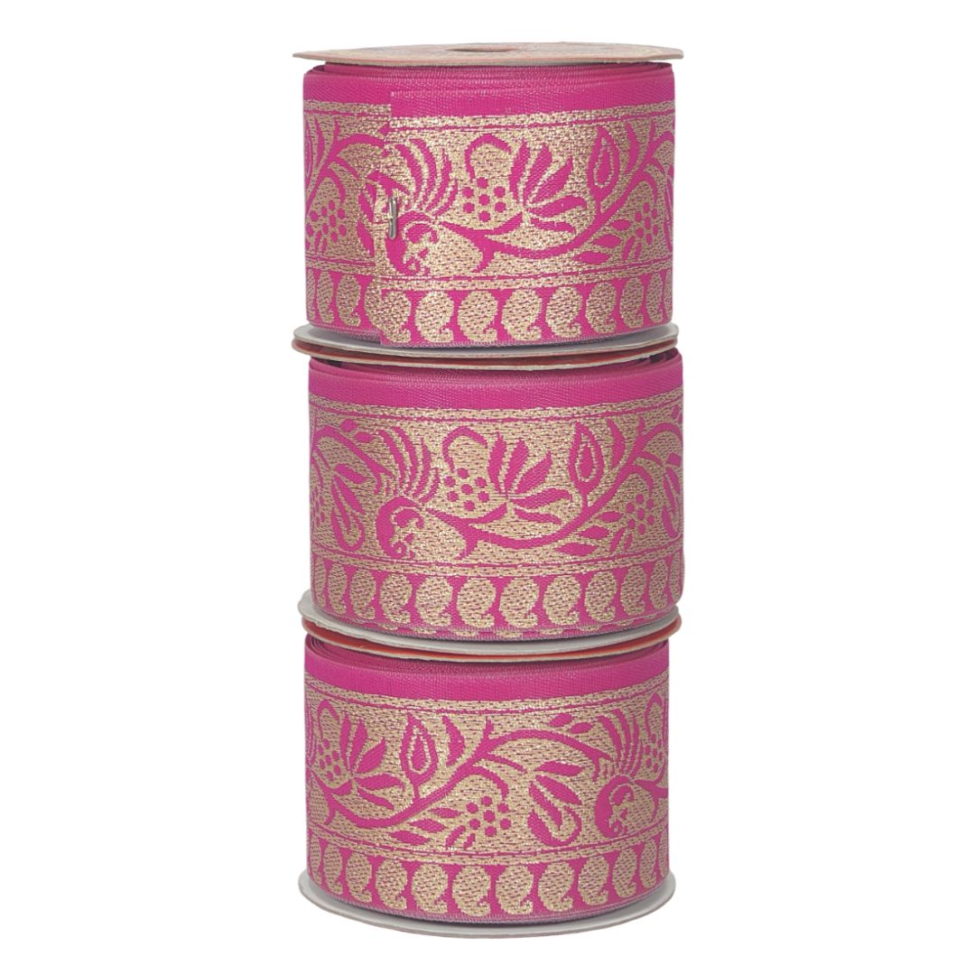 Three rolls of pink ribbon with gold floral patterns on a white background
