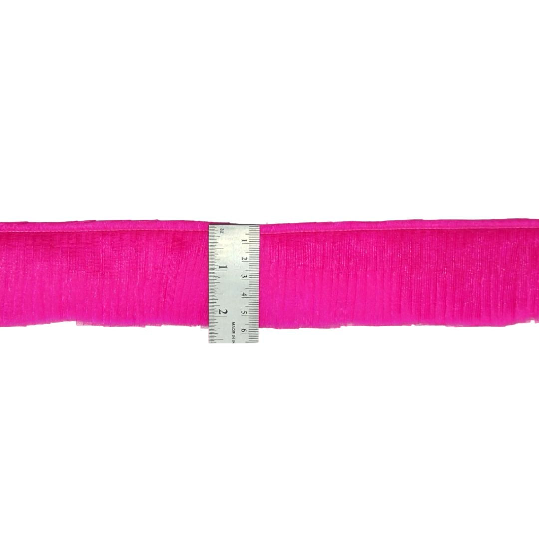 Pink ribbon with a ruler for measurement on a white background