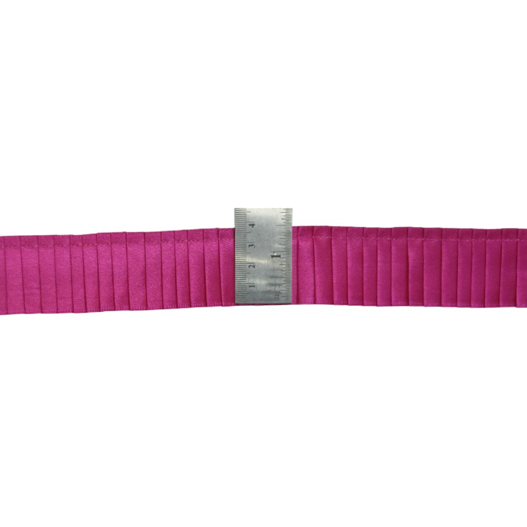 Pink belt with a metal ruler on a white background