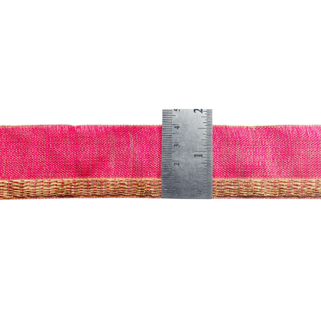 Pink woven belt with gold and a ruler for scale on a white background