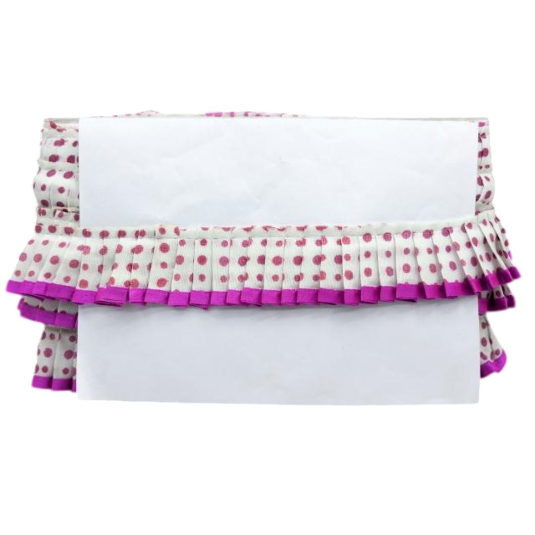 White surface with a polka dot fabric cover featuring pink and purple ruffles on a white background.