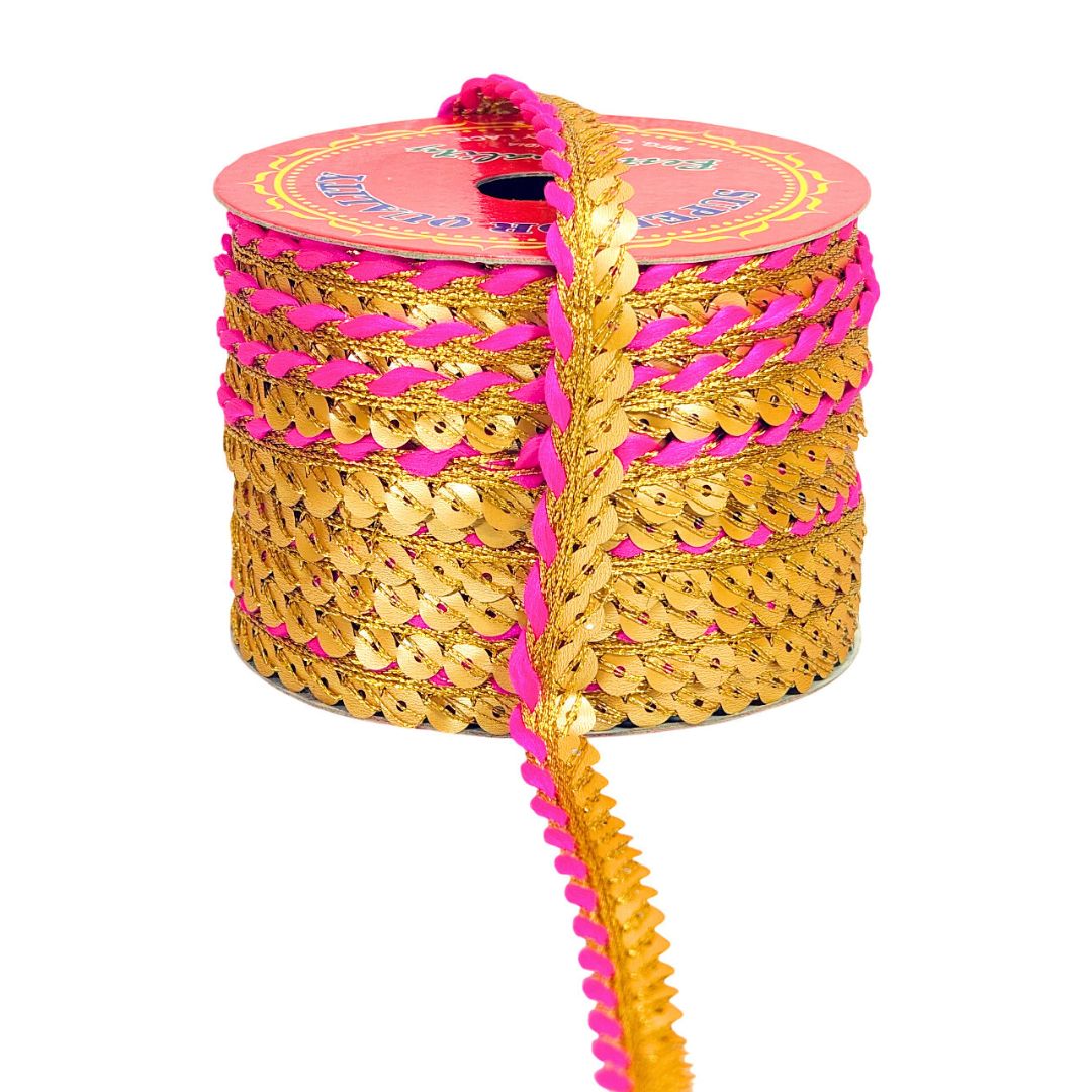 Gold and pink sequin ribbon on a spool with a white background