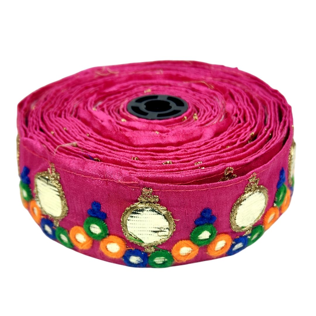 Roll of pink fabric with decorative patterns on a white background