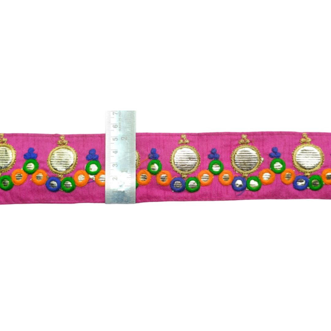 Decorative belt with colorful patterns and a ruler for scale on a white background