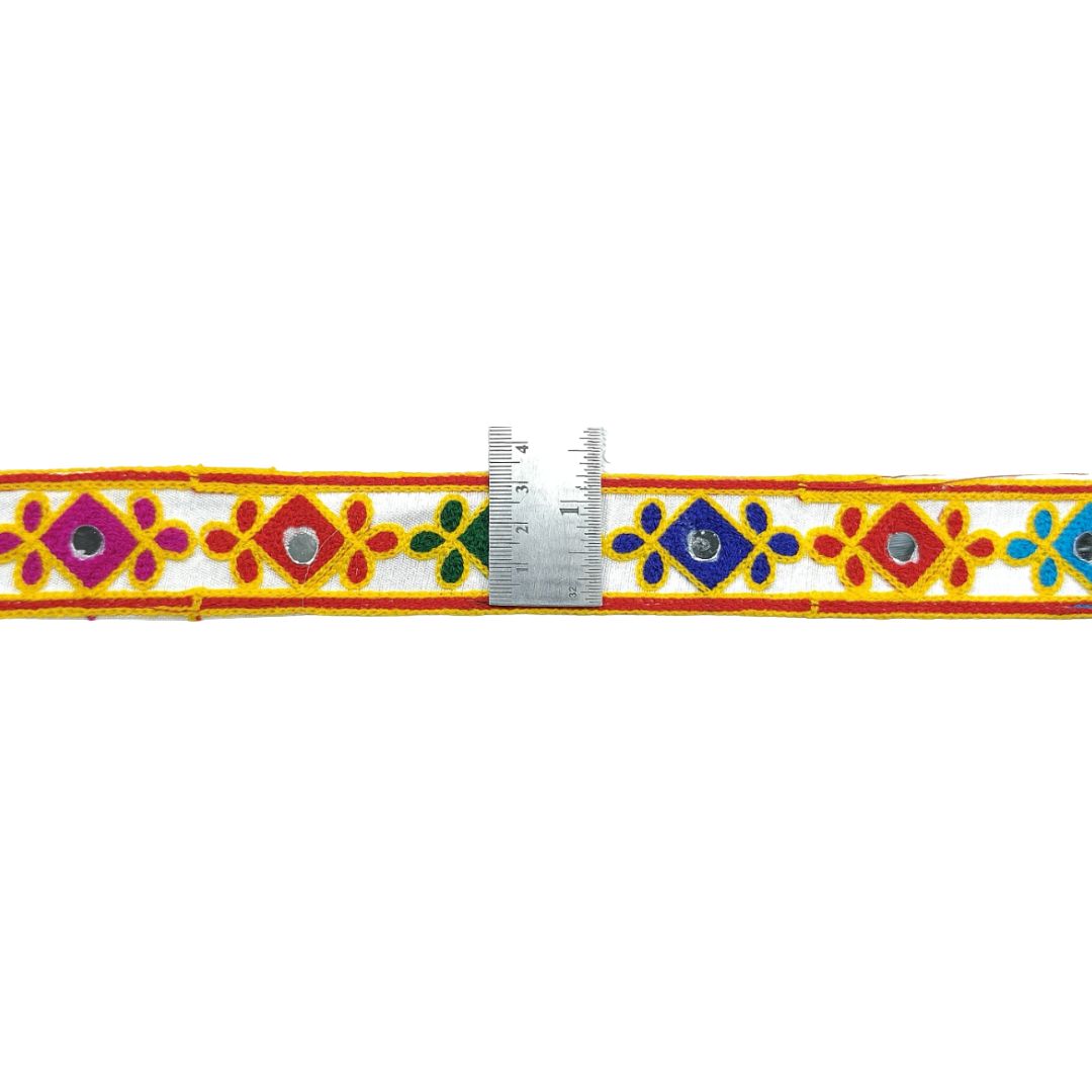 Decorative belt with colorful patterns and a ruler for scale on a white background