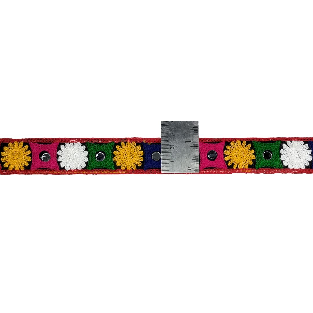 Colorful belt with floral patterns and a ruler for scale on a white background