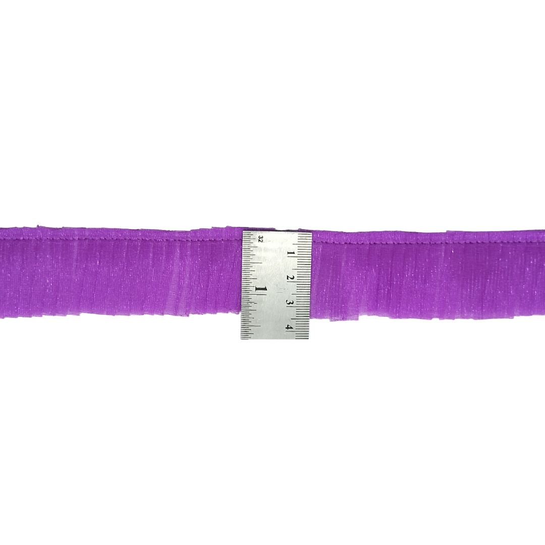 Purple ribbon with a ruler for scale on a white background