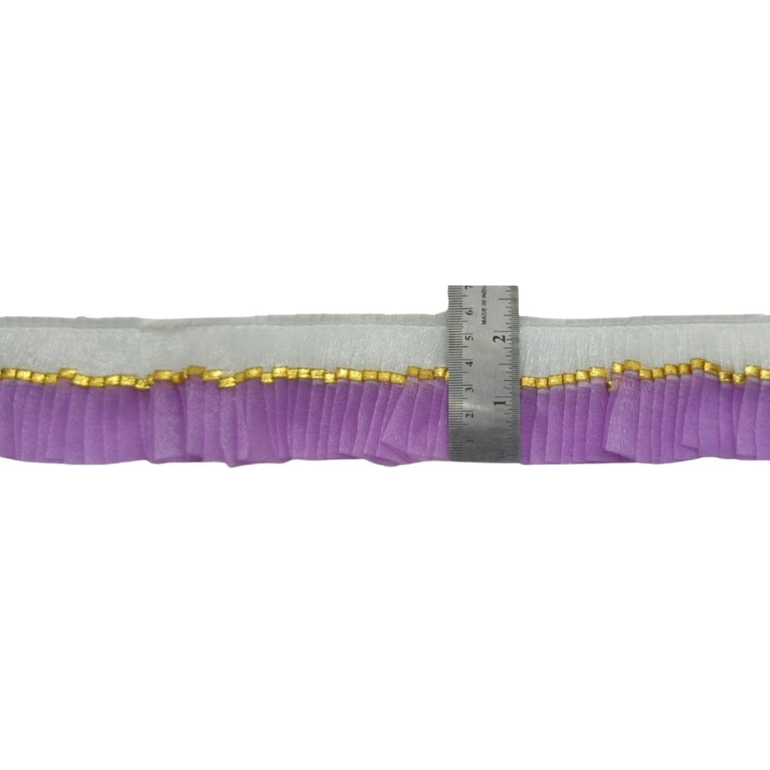 Purple elastic band with gold trim and a ruler for scale on a white background