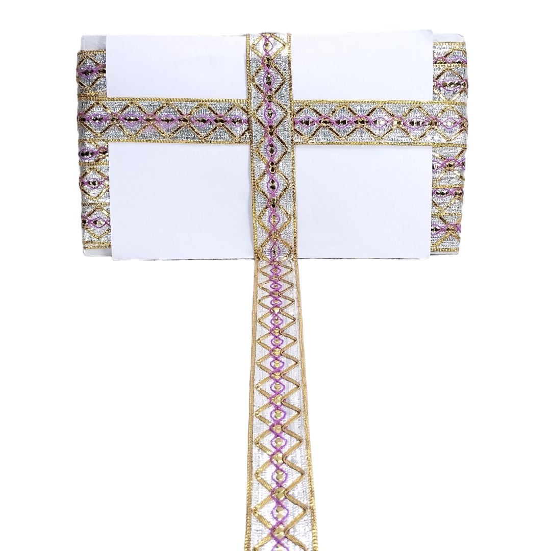 Decorative table runner with pink and gold embellishments on a white background