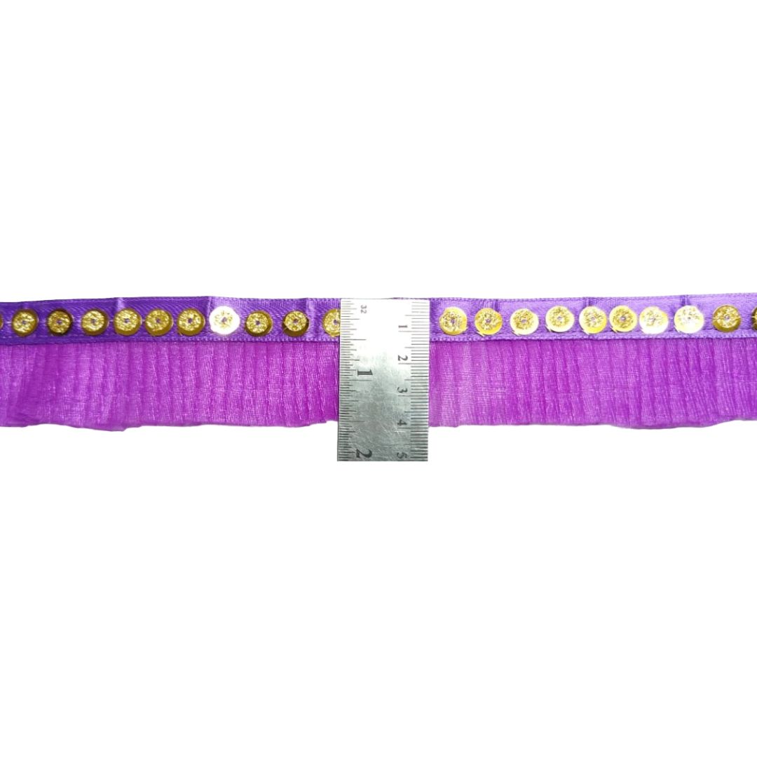 Purple ribbon with gold buttons and a ruler for measurement on a white background