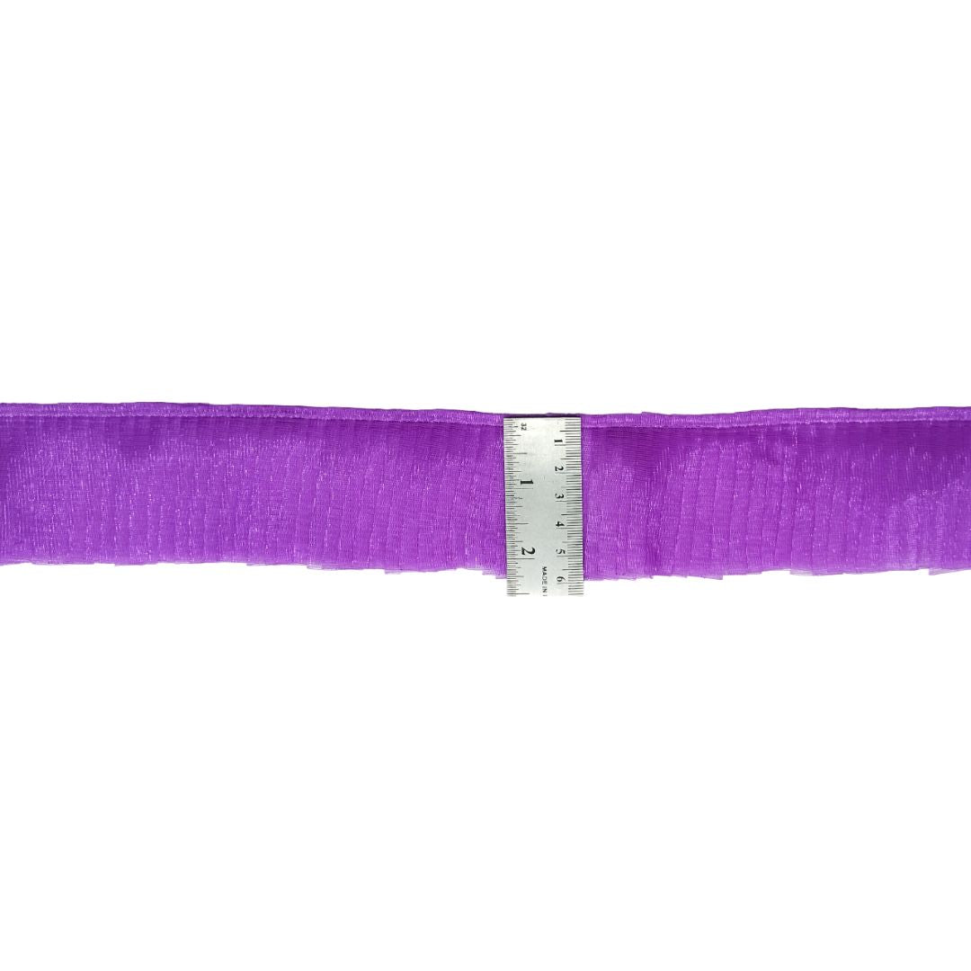 Purple ribbon with a ruler for scale on a white background