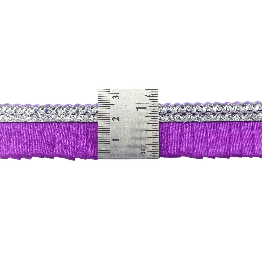 Purple ribbon with silver embellishments and a ruler for measurement on a white background