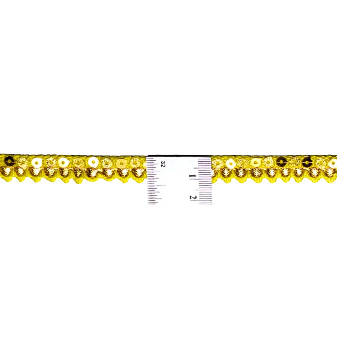 Decorative trim with yellow floral pattern and a ruler for scale on a white background