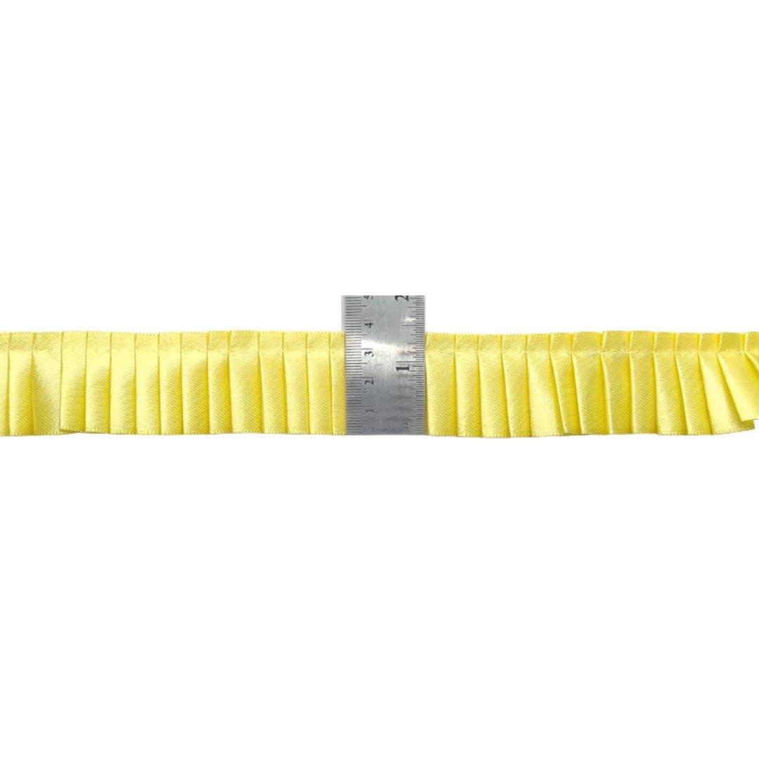 Yellow ribbon with a ruler for scale on a white background