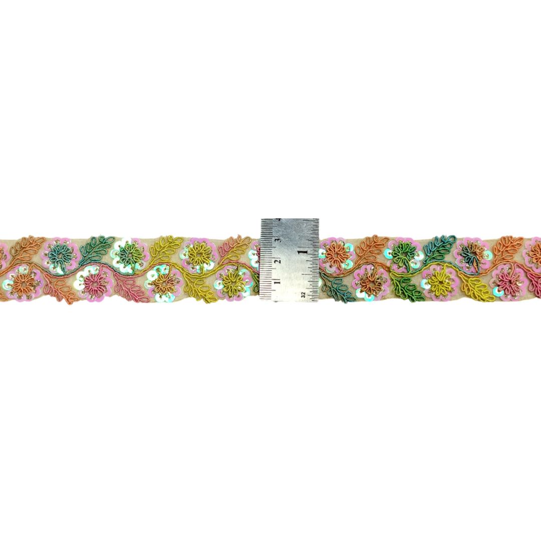 Decorative floral ribbon with a ruler for scale on a white background