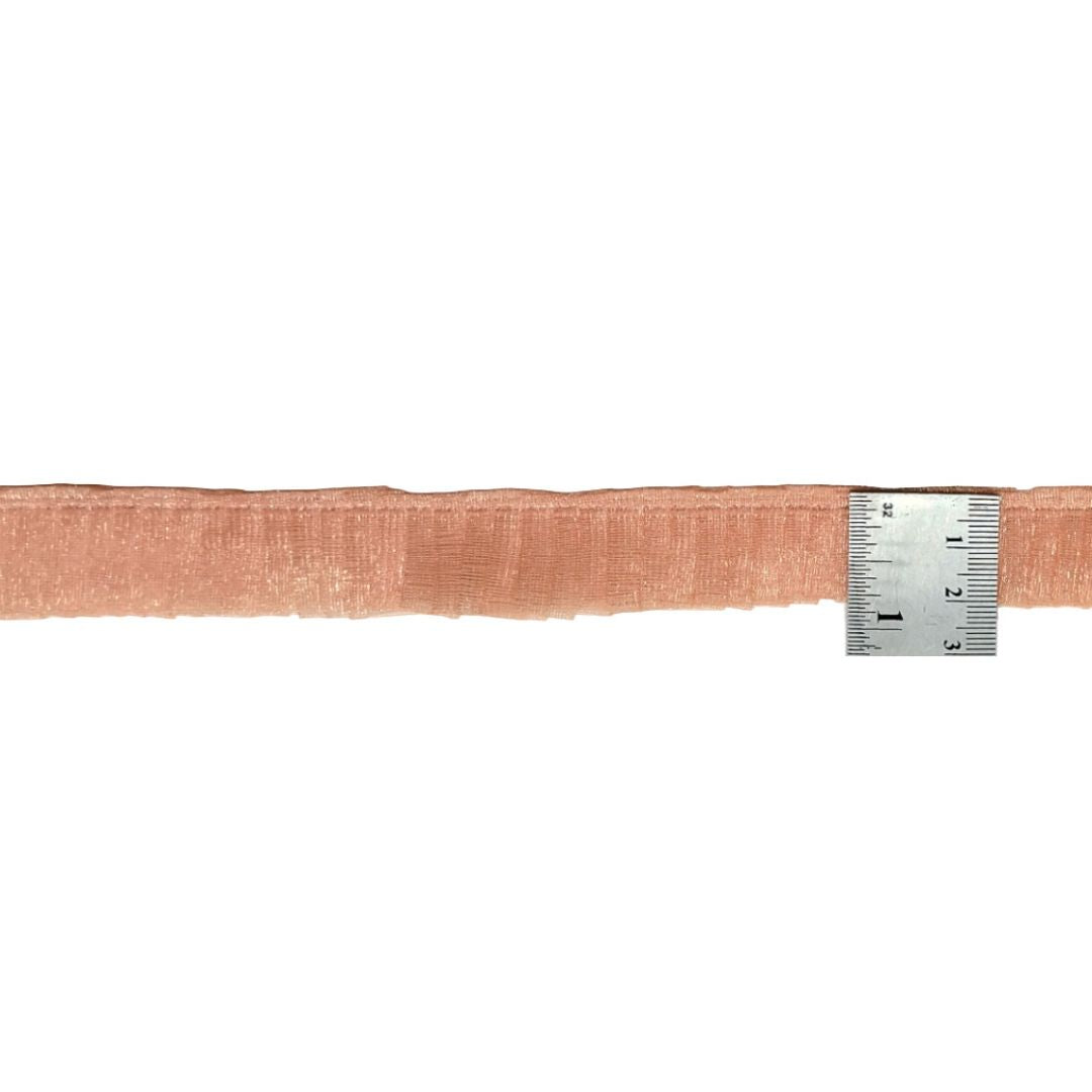 Strip of pink fabric with a ruler for scale on a white background
