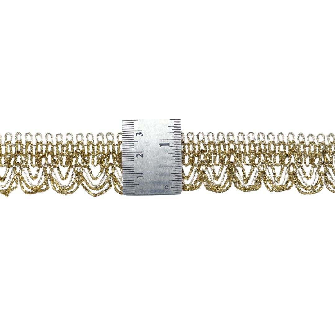 Gold lace trim with a ruler for scale on a white background