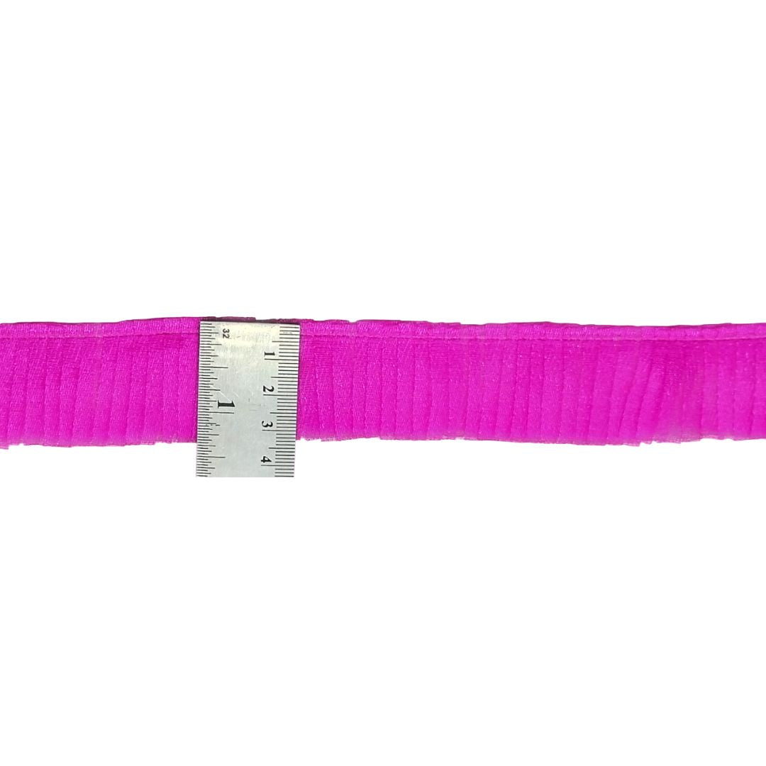 Pink ribbon with a ruler for measurement on a white background