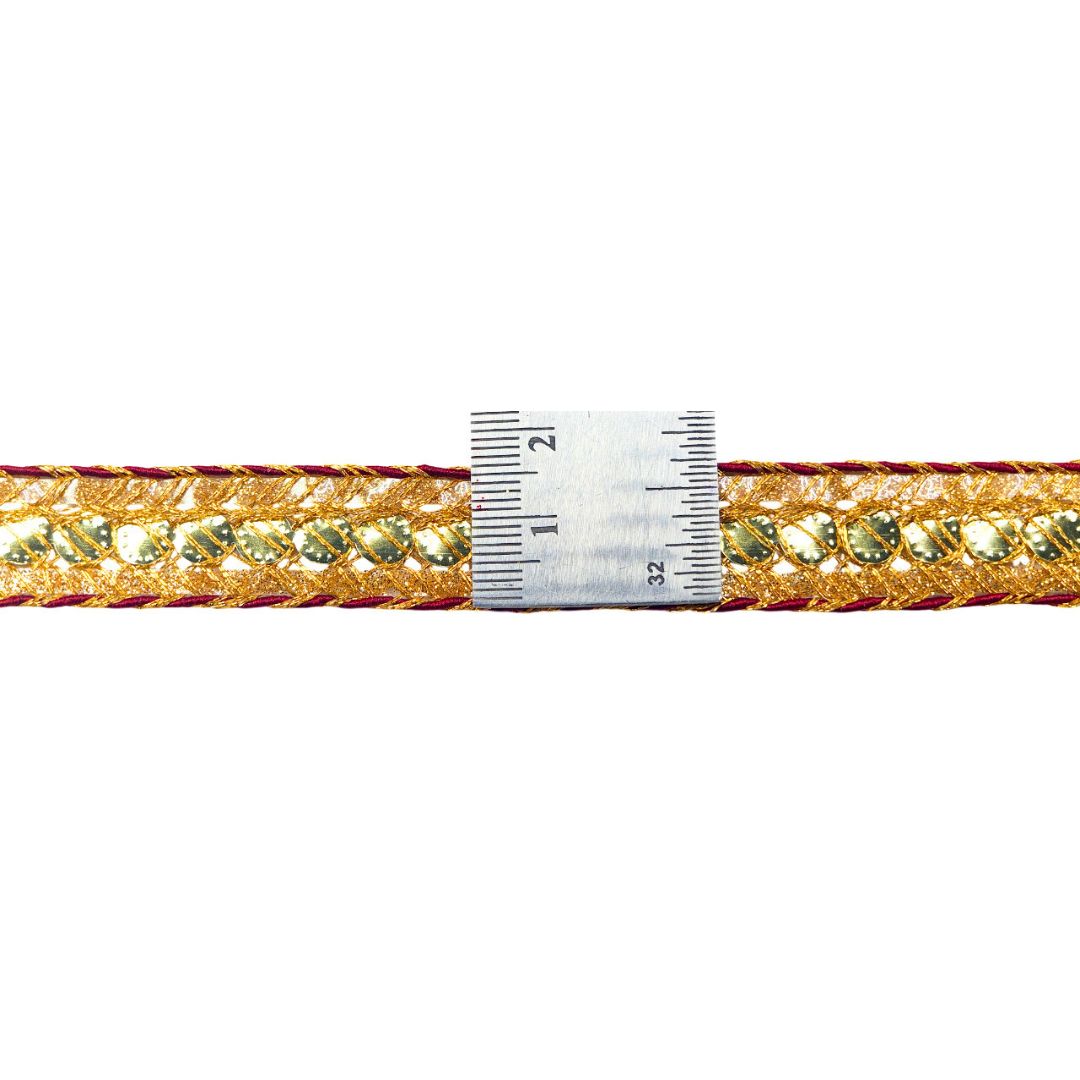 Gold and red braided cord with a ruler for scale on a white background