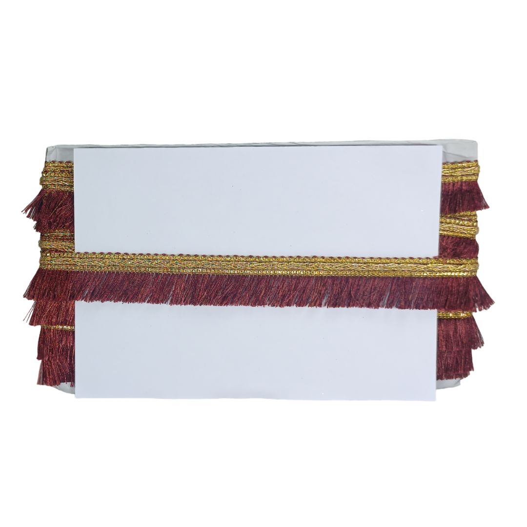 White clutch bag with gold and burgundy fringe on a white background