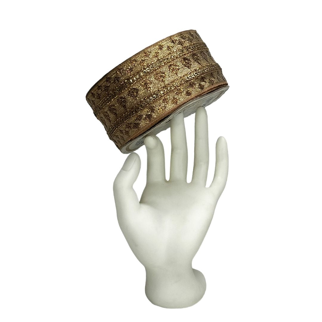 Decorative headband on a white mannequin hand against a white background