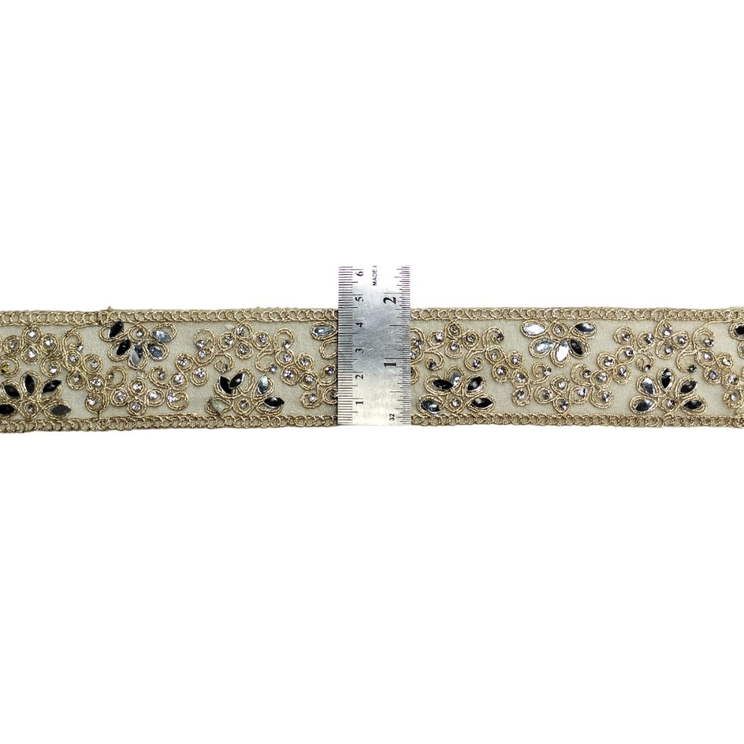 Decorative ribbon with crystals and a ruler for scale on a white background
