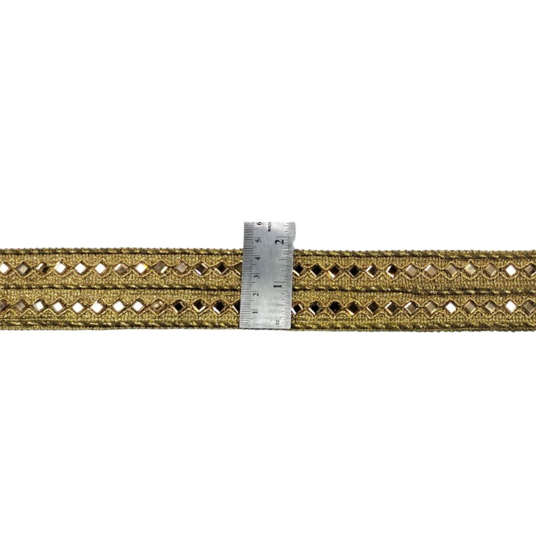 Gold braided trim with a ruler for scale on a white background