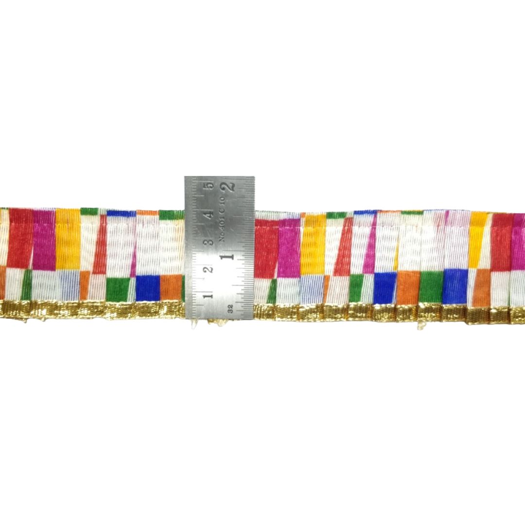 Multicolored striped ribbon with a ruler for scale on a white background