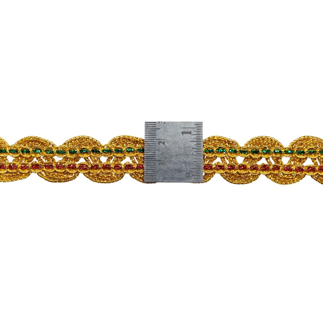 Decorative gold chain with embedded red and green stones, measured against a ruler on a white background.