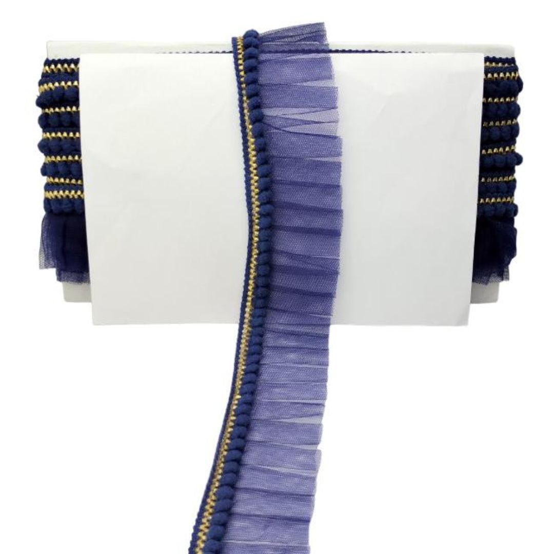 White clutch with blue fringe and gold accents on a white background