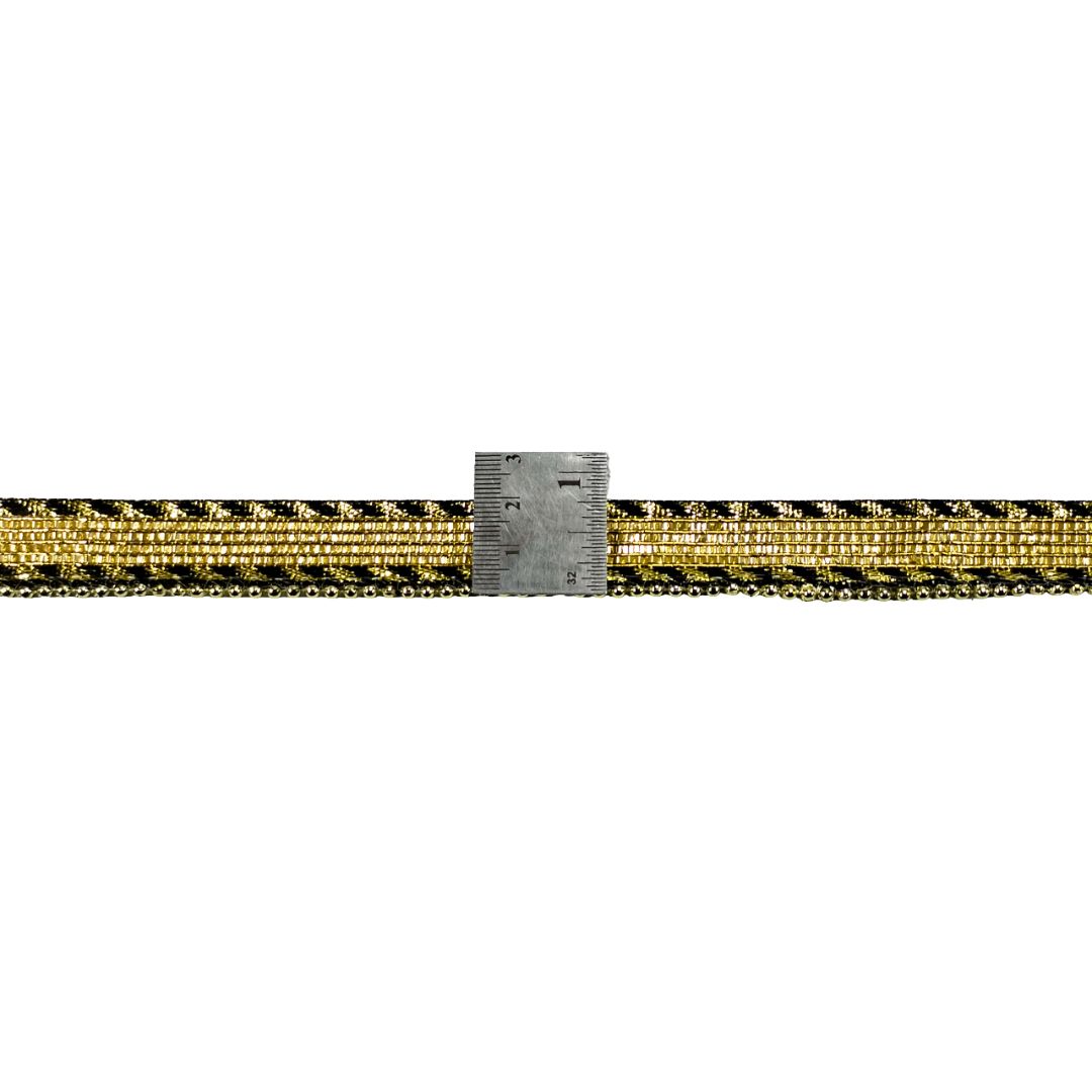 Gold and black patterned belt with a ruler for scale on a white background